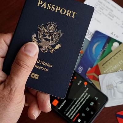 A passport held in one hand above a table